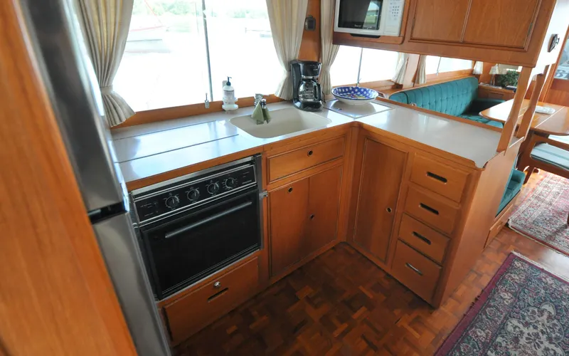 Slide: The Image of 2000 Grand Banks Heritage Europa 52 yacht kitchen with wood cabinetry and modern appliances. - 47