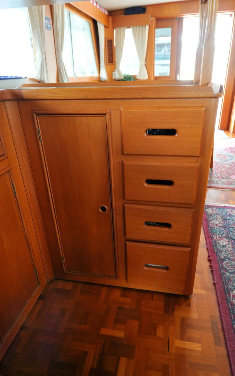 Slide: The Image of Wooden cabinetry inside a 2000 Grand Banks Heritage Europa 52 yacht, featuring drawers and a door. - 48