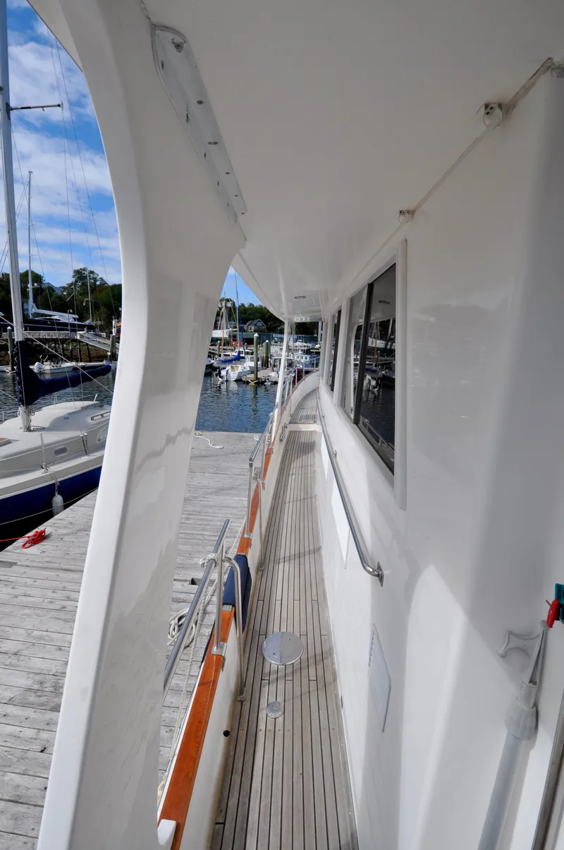 Slide: The Image of Side deck view of 2000 Grand Banks Heritage Europa 52 yacht at marina. - 7