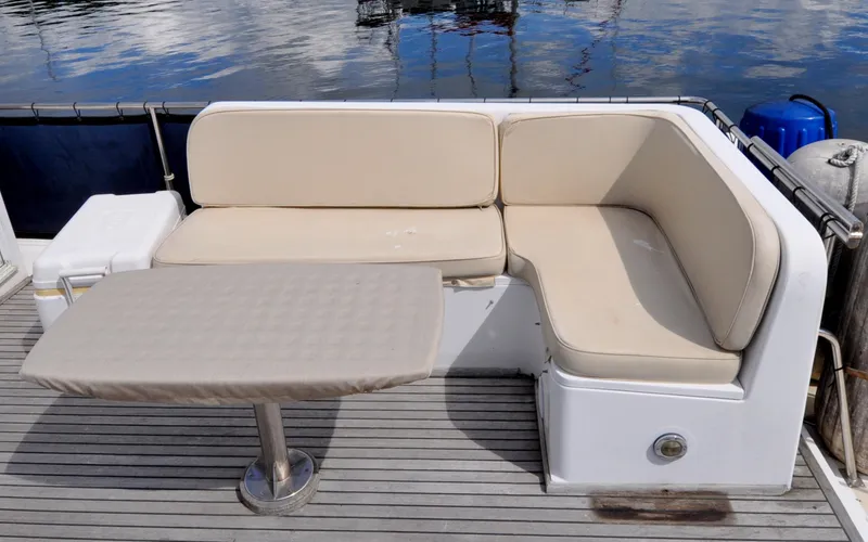 Slide: The Image of Grand Banks Heritage Europa 52, 2000 model, features a cushioned outdoor seating area with a table. - 21