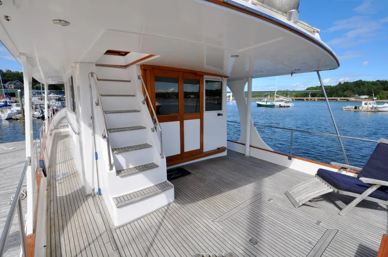 Slide: The Image of Grand Banks Heritage Europa 52 yacht deck with stairs and seating, docked by the water. - 5