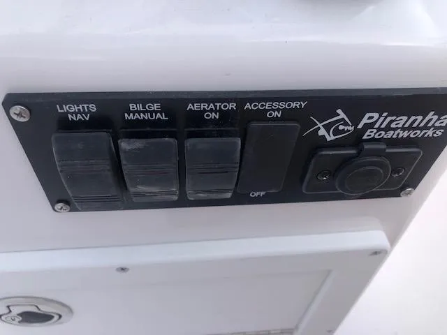 Slide: The Image of Control panel of Piranha Alvo F1700 boat, featuring switches for lights, bilge, aerator, and accessories. - 12