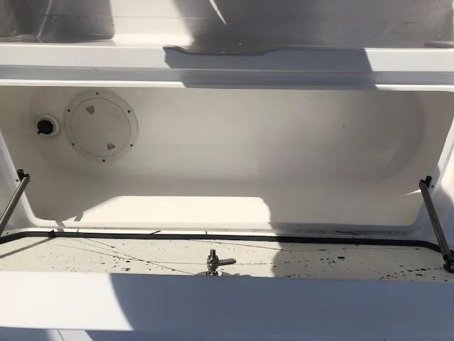 Slide: The Image of Open storage compartment of Piranha Alvo F1700 boat, 2025 model, with visible latch and drain. - 14