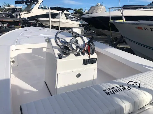 Slide: The Image of 2025 Piranha Alvo F1700 boat interior with steering console and seating in marina. - 6