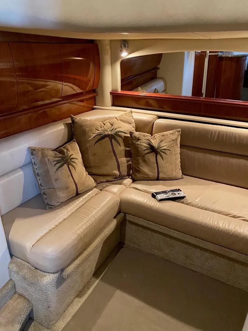 Slide: The Image of 2006 Sea Ray 44 Sundancer interior with beige leather seating and palm tree pillows. - 23