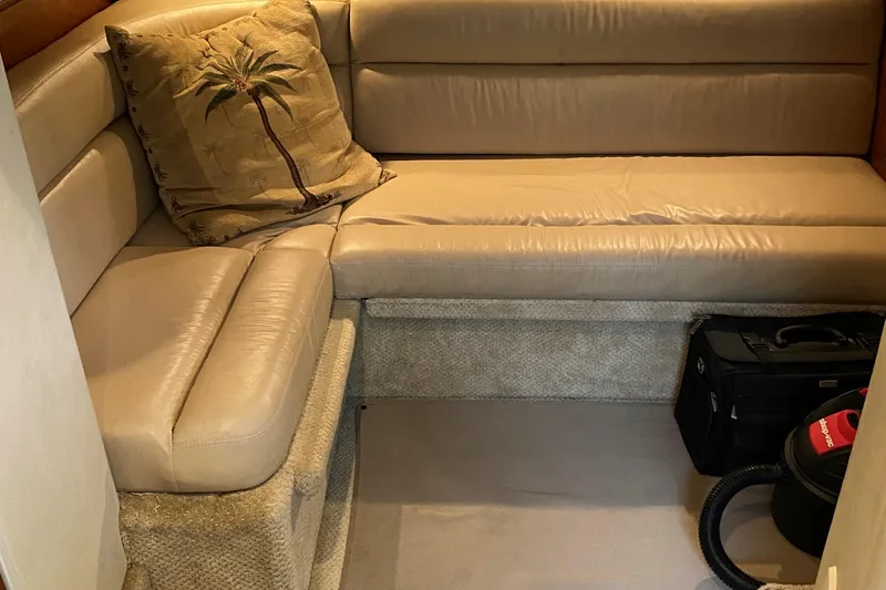 Slide: The Image of 2006 Sea Ray 44 Sundancer interior lounge with beige leather seating and palm tree pillow. - 27