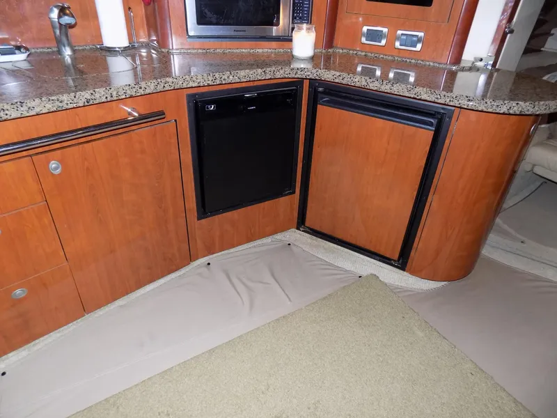 Slide: The Image of 2006 Sea Ray 44 Sundancer galley with wood cabinetry and granite countertops. - 37