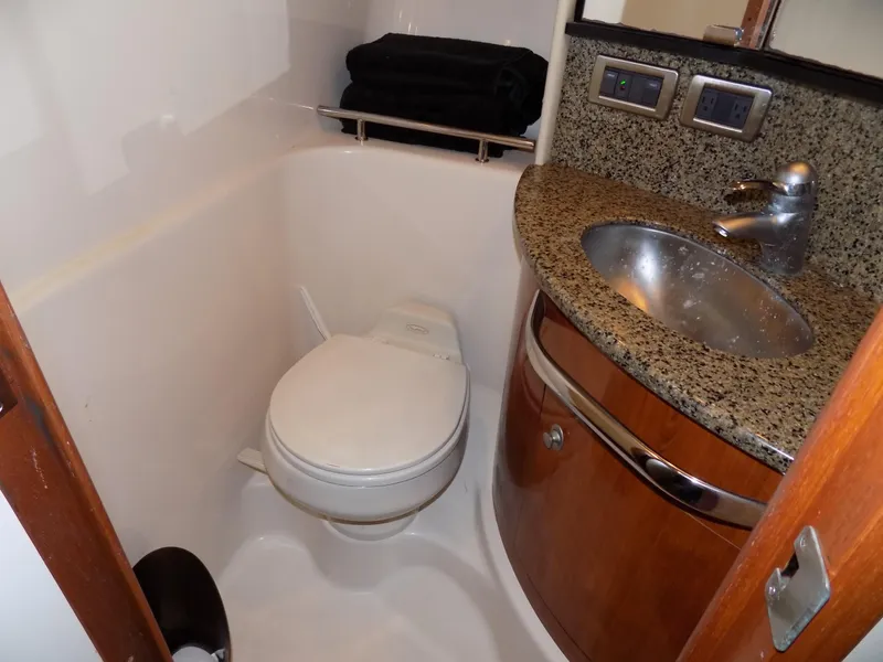 Slide: The Image of Compact bathroom in 2006 Sea Ray 44 Sundancer yacht with granite countertop and stainless steel sink. - 49