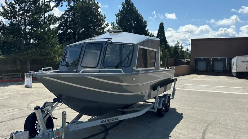 Slide: The Image of 2025 Spartan 215 Athens boat on trailer, parked outdoors under a clear sky. - 2