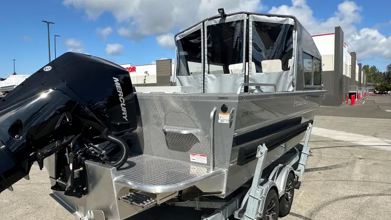 Slide: The Image of 2025 Spartan 215 Athens boat with Mercury engine on trailer, parked outdoors. - 9