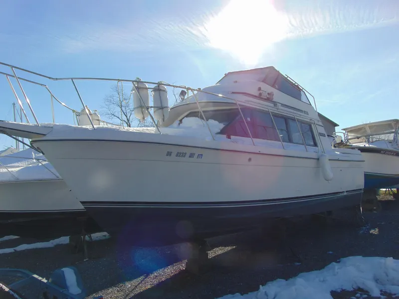 The Image of 1987 Carver Mariner 28 boat in snowy outdoor setting, sun shining above. - 1