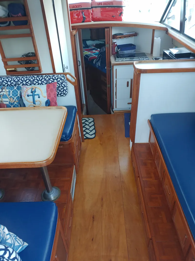 Slide: The Image of Interior of 1987 Carver Mariner 28 boat with blue seating and wooden flooring. - 5