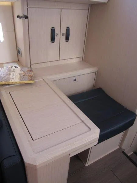 Slide: The Image of Interior of 2024 Jeanneau 60 yacht with light wood finish and black seating. - 9