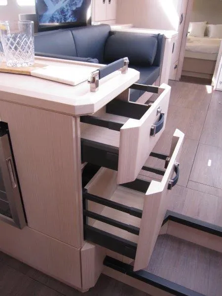 Slide: The Image of Modern interior of 2024 Jeanneau 60 yacht with open drawers in the kitchen area. - 13