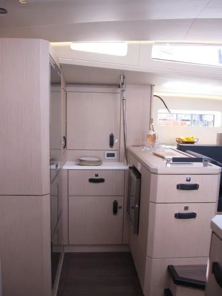 Slide: The Image of Modern kitchen area in the 2024 Jeanneau 60 yacht with light wood cabinetry. - 19