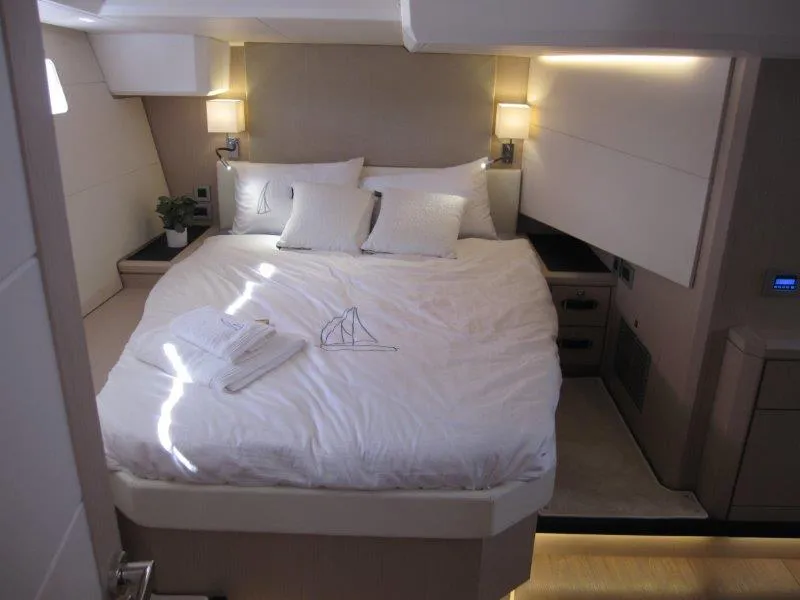 Slide: The Image of Luxurious bedroom in 2024 Jeanneau 60 yacht with modern lighting and cozy bedding. - 2