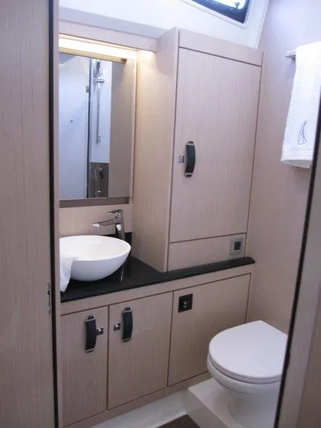 Slide: The Image of Modern bathroom in 2024 Jeanneau 60 yacht with sink, toilet, and storage cabinets. - 42
