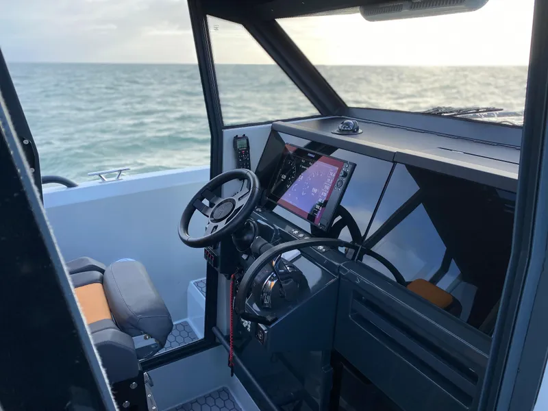 Slide: The Image of 2023 XO Boats Defender 9 cockpit with steering wheel and navigation system. - 15