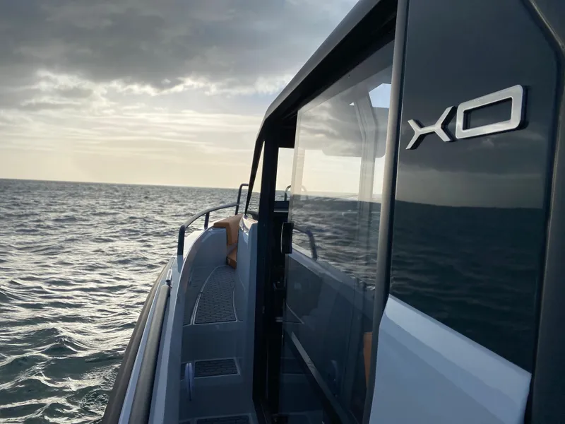 Slide: The Image of 2023 XO Boats Defender 9 on open water at sunset. - 18