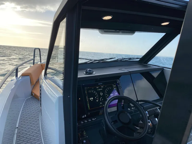 Slide: The Image of 2023 XO Boats Defender 9 cockpit with ocean view at sunset. - 20