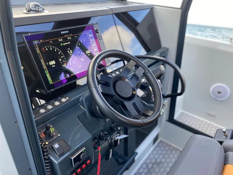 Slide: The Image of 2023 XO Boats Defender 9 cockpit with advanced navigation system and steering wheel. - 21