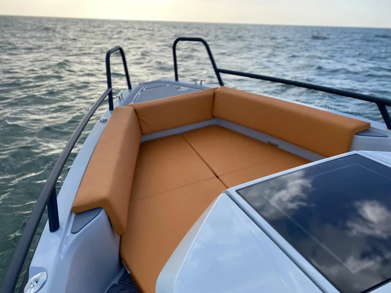 Slide: The Image of 2023 XO Boats Defender 9 with cushioned seating on the bow, cruising on the ocean. - 24