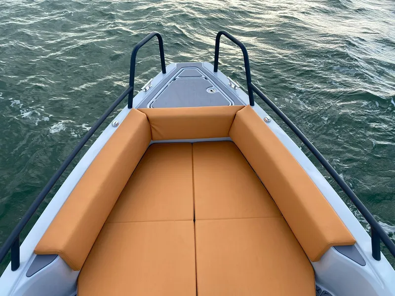 Slide: The Image of 2023 XO Boats Defender 9 with orange cushioned seating on the bow, floating on water. - 26