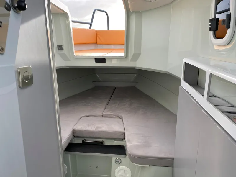 Slide: The Image of Interior cabin of 2023 XO Boats Defender 9 with grey cushions and orange seating. - 29