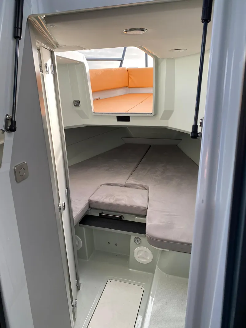 Slide: The Image of 2023 XO Boats Defender 9 cabin interior with grey and orange seating. - 30