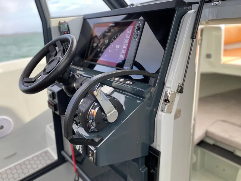 Slide: The Image of 2023 XO Boats Defender 9 helm station with modern controls and touchscreen display. - 31