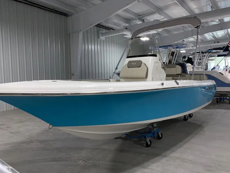 Slide: The Image of 2024 Key West 189 FS boat in showroom, blue and white hull, center console. - 3