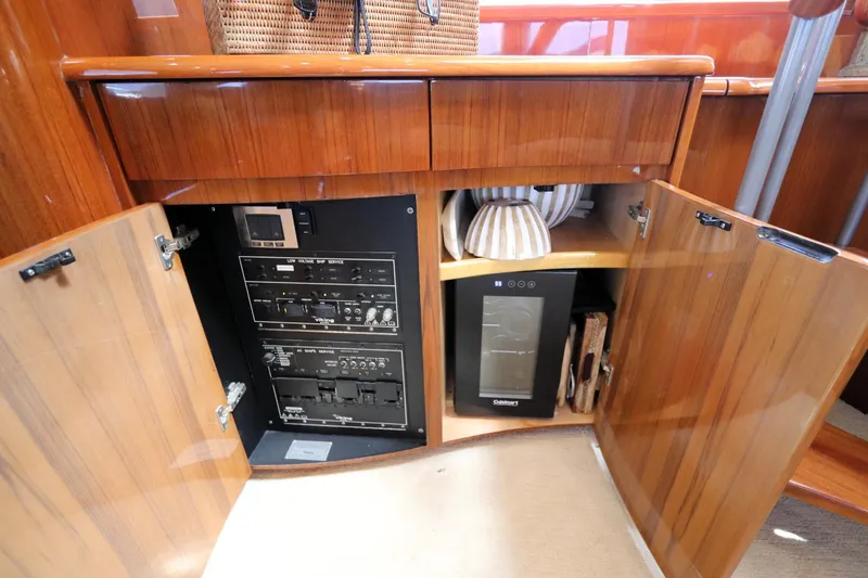 Slide: The Image of 2013 Viking 66 yacht interior with open wooden cabinets revealing control panels and storage. - 24