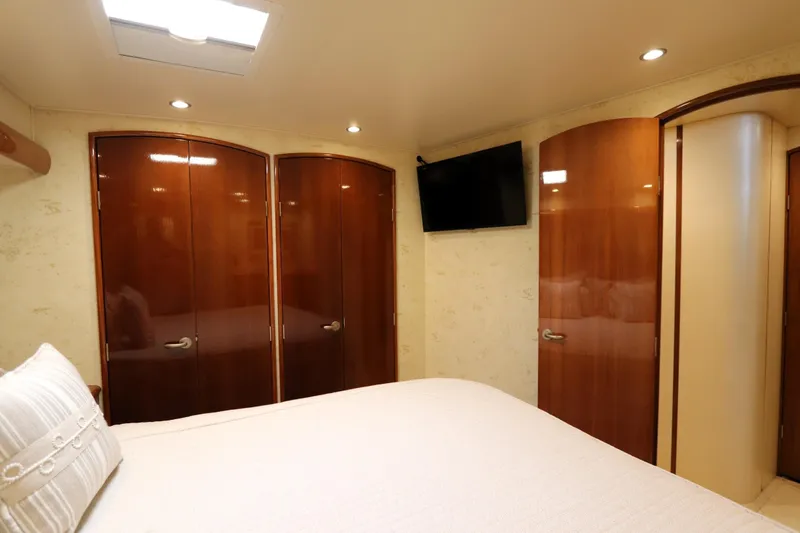 Slide: The Image of Luxurious bedroom interior of 2013 Viking 66 yacht with wooden doors and mounted TV. - 30