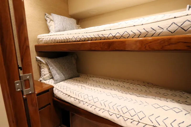 Slide: The Image of Bunk beds in 2013 Viking 66 yacht cabin with patterned bedding and wooden accents. - 35