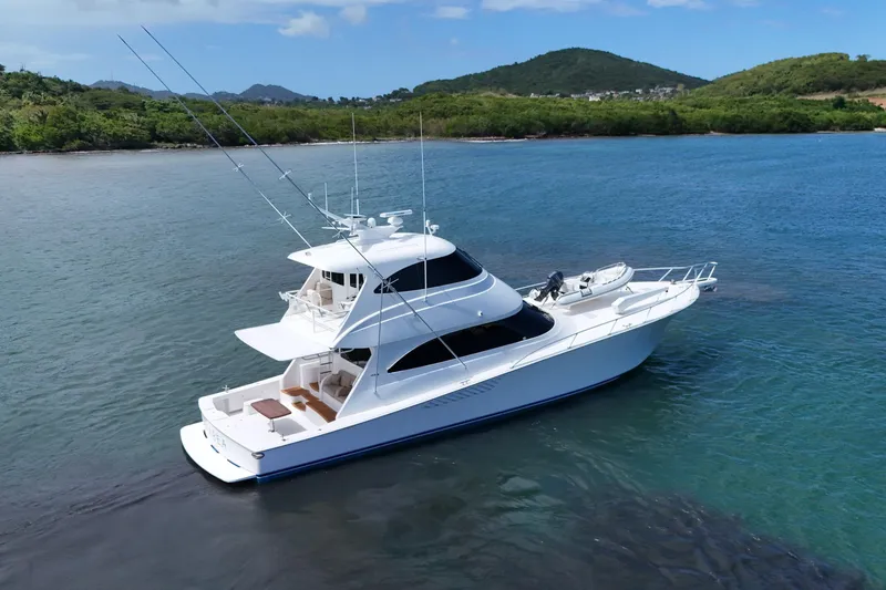 Slide: The Image of Luxurious 2013 Viking 66 yacht cruising in serene blue waters near lush green hills. - 4