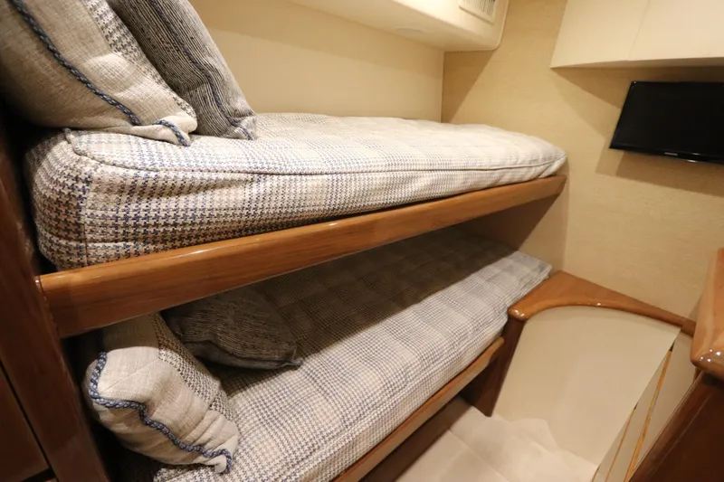 Slide: The Image of Bunk beds in 2013 Viking 66 yacht cabin with cozy cushions and wooden finish. - 41