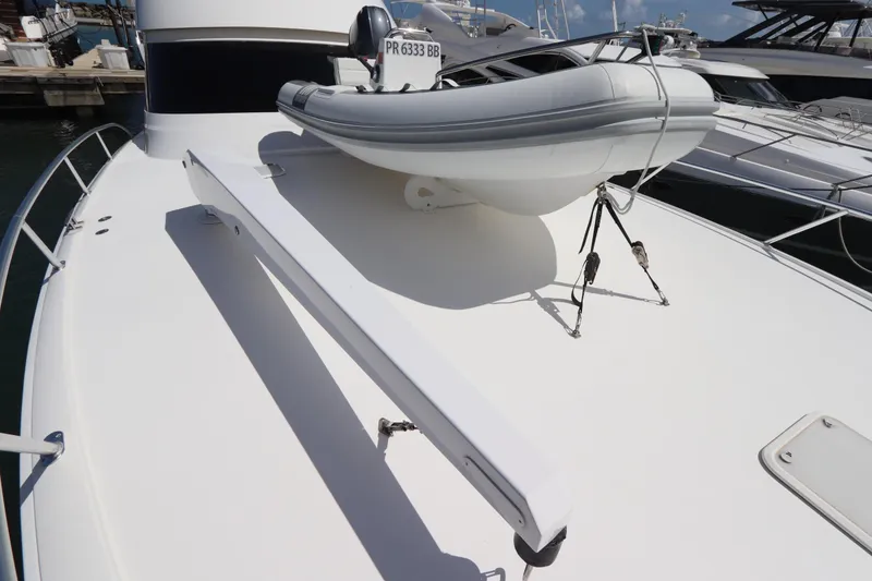 Slide: The Image of 2013 Viking 66 yacht with inflatable boat on deck, docked at marina. - 58