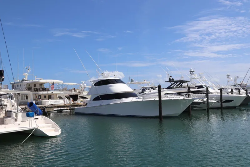 Slide: The Image of Luxury yachts docked at marina, featuring a 2013 Viking 66 model under clear blue skies. - 61