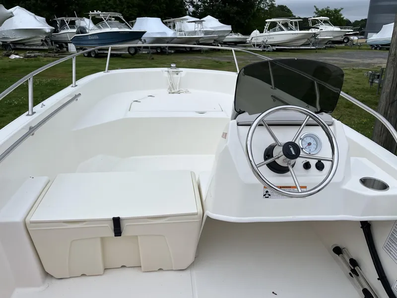 Slide: The Image of 2024 Boston Whaler 160 Super Sport boat interior with steering console and seating. - 10