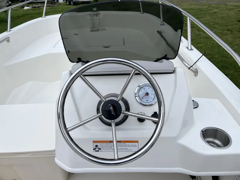 Slide: The Image of 2024 Boston Whaler 160 Super Sport boat steering console with stainless steel wheel and gauge. - 11