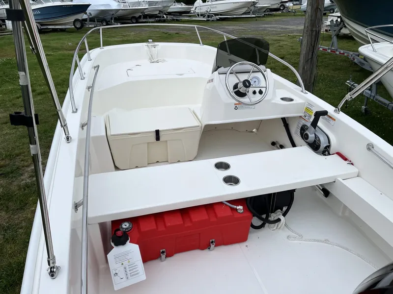 Slide: The Image of 2024 Boston Whaler 160 Super Sport boat interior with steering console and seating. - 4