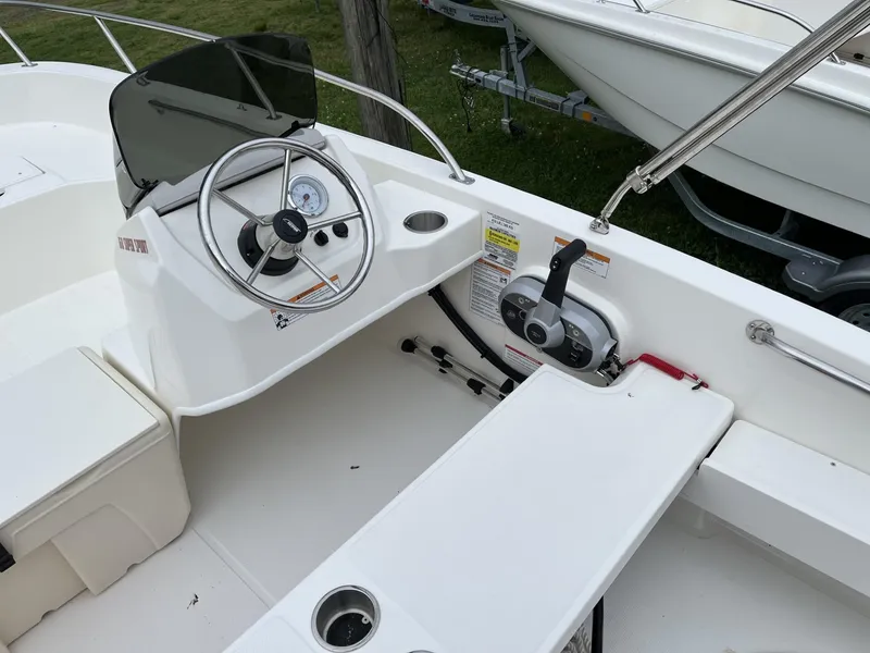 Slide: The Image of 2024 Boston Whaler 160 Super Sport boat interior with steering console and seating. - 5