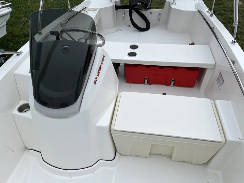 Slide: The Image of 2024 Boston Whaler 160 Super Sport boat interior with seating and storage compartments. - 8
