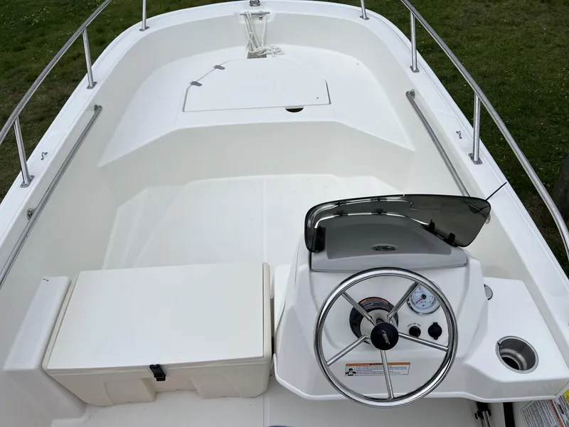 Slide: The Image of 2024 Boston Whaler 160 Super Sport boat interior with steering console and seating. - 9