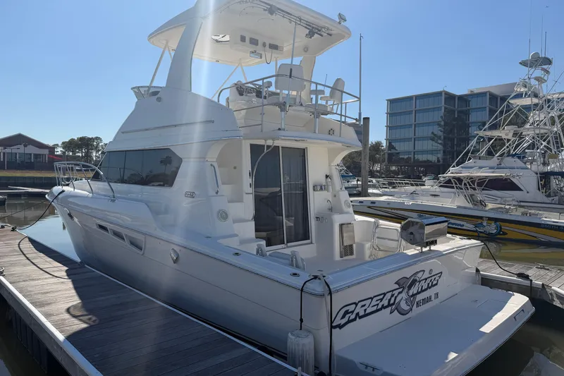 Slide: The Image of 2001 Silverton 42 Convertible yacht docked at marina under clear blue sky. - 4