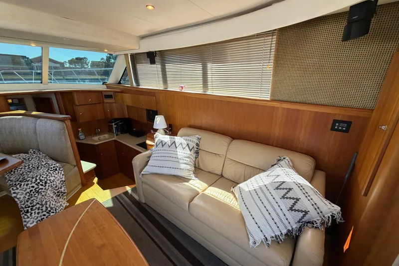 Slide: The Image of Interior of 2001 Silverton 42 Convertible yacht with beige sofa and wooden cabinetry. - 58