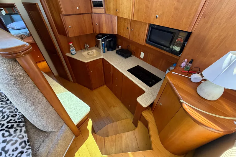 Slide: The Image of 2001 Silverton 42 Convertible yacht interior kitchen with wood cabinetry and modern appliances. - 60