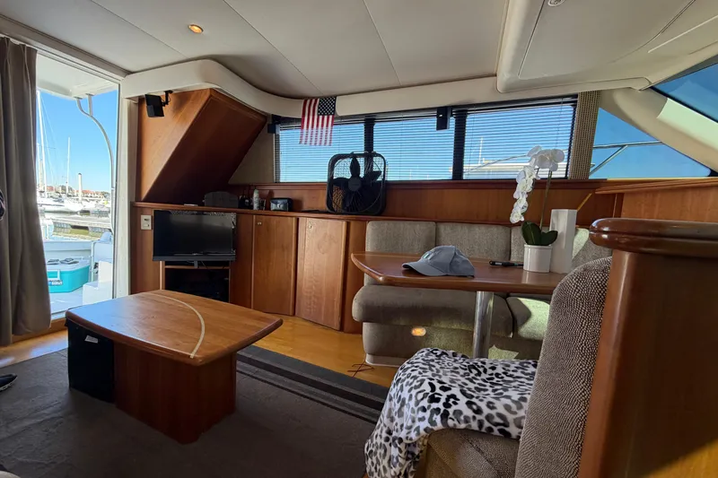 Slide: The Image of Interior of 2001 Silverton 42 Convertible yacht with cozy seating and wooden furnishings. - 62