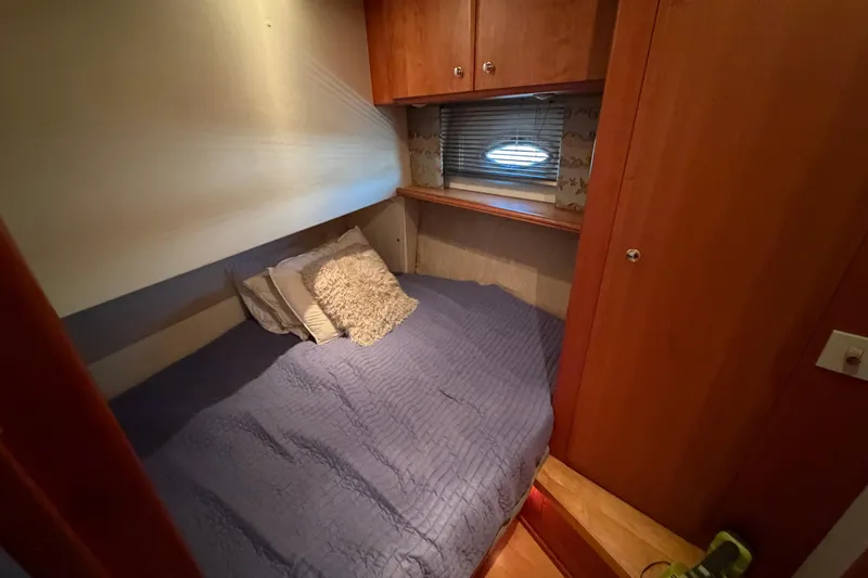 Slide: The Image of Cozy cabin interior of 2001 Silverton 42 Convertible yacht with bed and wooden cabinetry. - 63