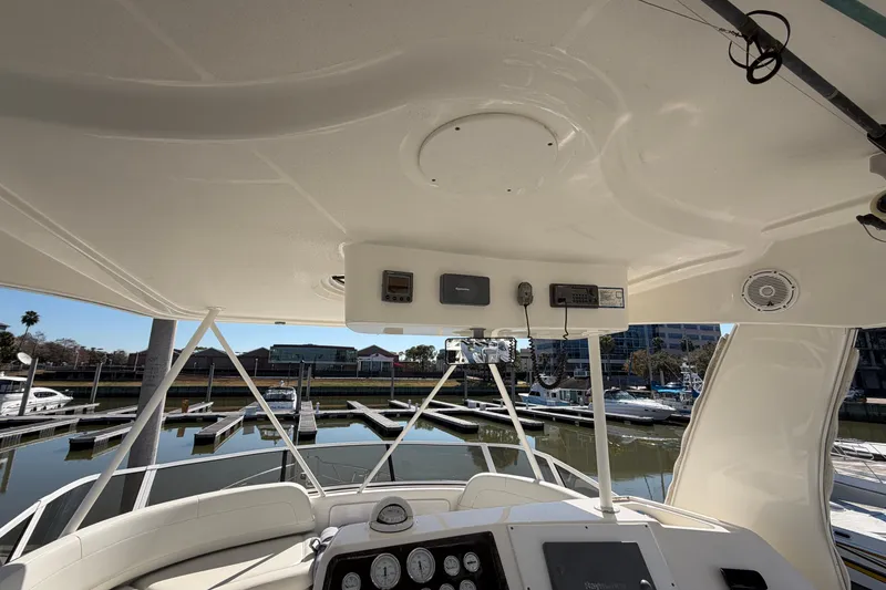 Slide: The Image of 2001 Silverton 42 Convertible yacht helm with marina view, featuring navigation equipment and controls. - 73